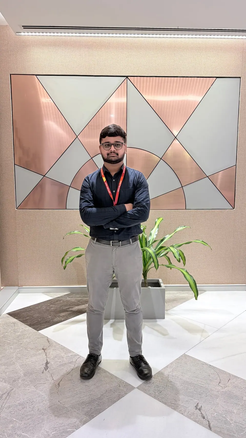 Anshul standing with arms crossed in a Hindalco office lobby
